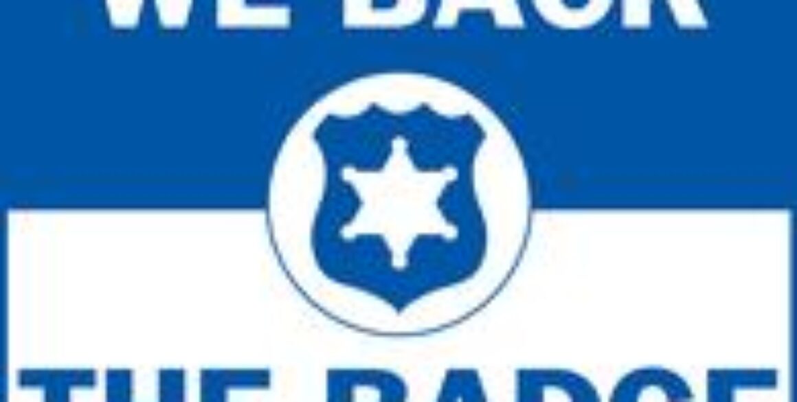 A blue and white "We Back The Badge" graphic.