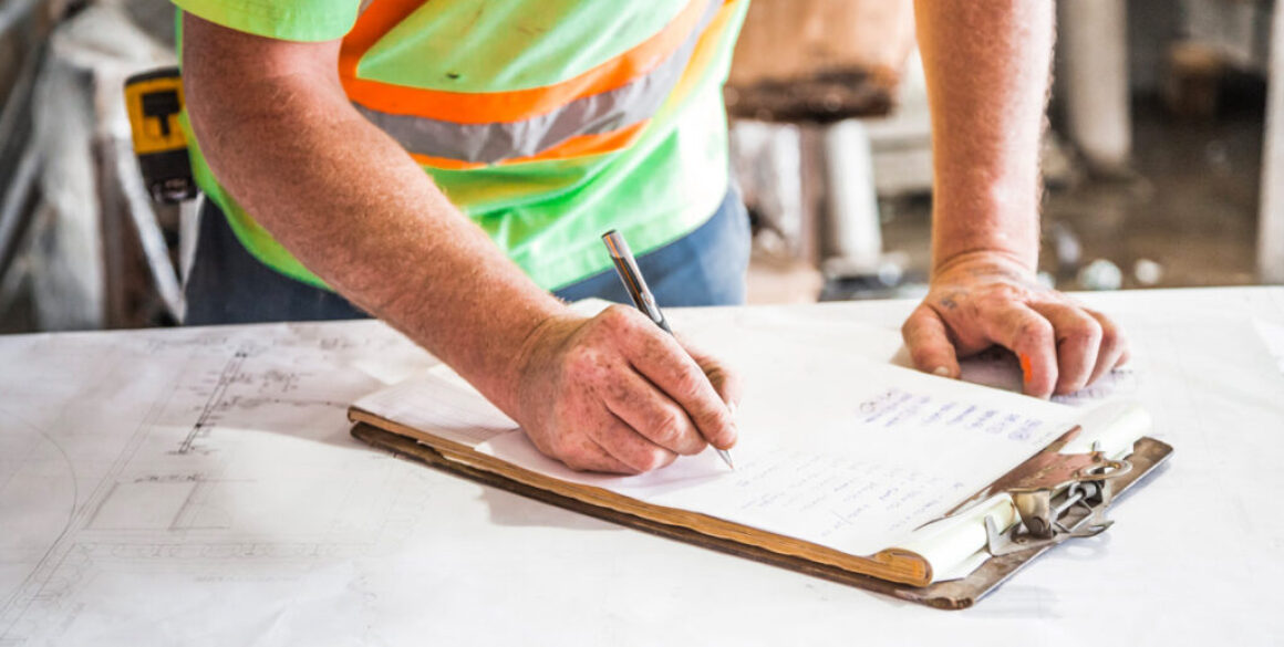 Contractor going over a checklist and blueprints on the jobsite.