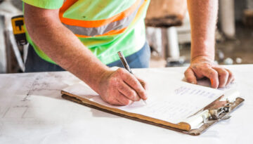 Contractor going over a checklist and blueprints on the jobsite.