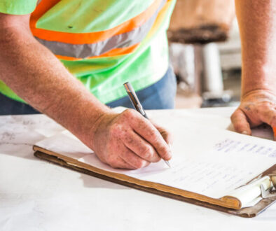 Contractor going over a checklist and blueprints on the jobsite.